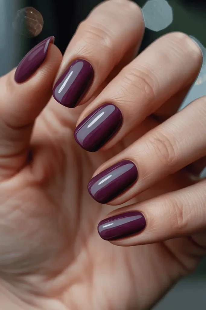 mulberry plum nails, deep luxurious purple-red color, glossy or velvet matte, elegant festive background, soft moody lighting, realistic hands