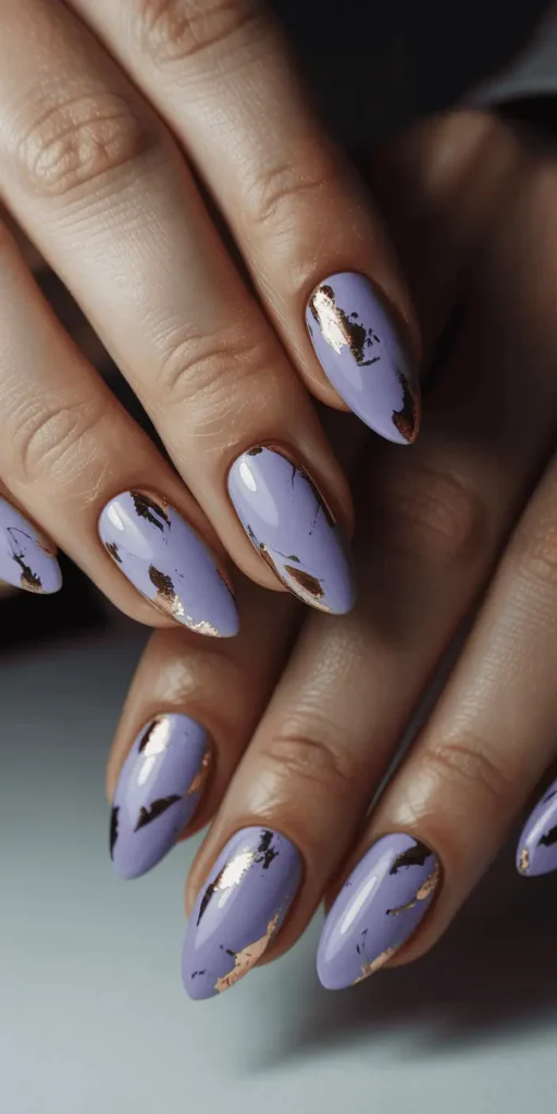 Soft lavender purple nails with scattered gold foil flakes, artistic romantic Valentine's nail design