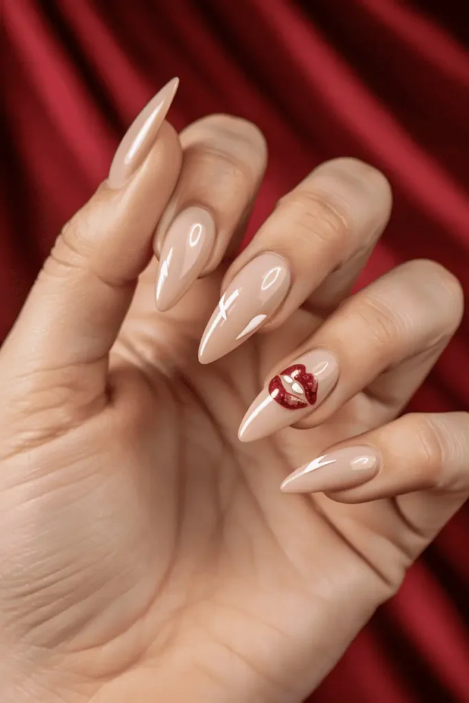Nude nails with cartoon vampire fangs, red glitter lips accent nail. Glossy finish, styled against red velvet background.