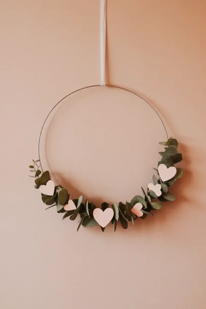 “minimal Valentine’s wreath on metal hoop with small heart accents, neutral background, clean modern style, soft blush tones, lots of negative space, gentle daylight, realistic photography, no text, 2:3 vertical”