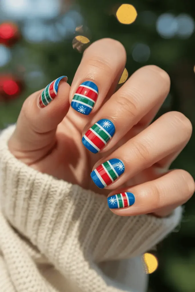 nails with colorful sweater patterns, bold stripes red green white blue, tiny snowflakes, cozy knit textures in background, warm holiday lighting, realistic hands
