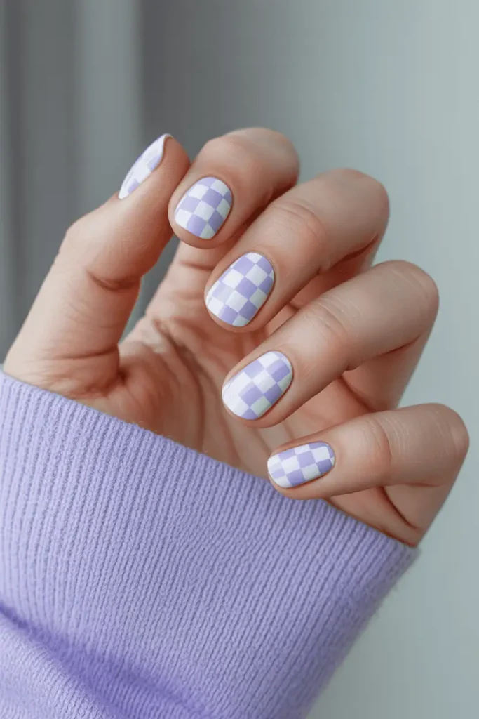 pastel checkerboard nails in soft lavender and white, realistic hands, crisp detail, modern clean background, spring-inspired soft lighting, Pinterest-ready