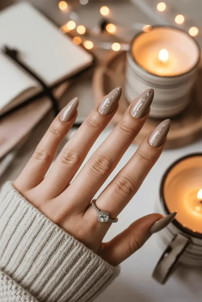 Taupe nails with fine glitter vertical stripe, neutral background, candlelight.