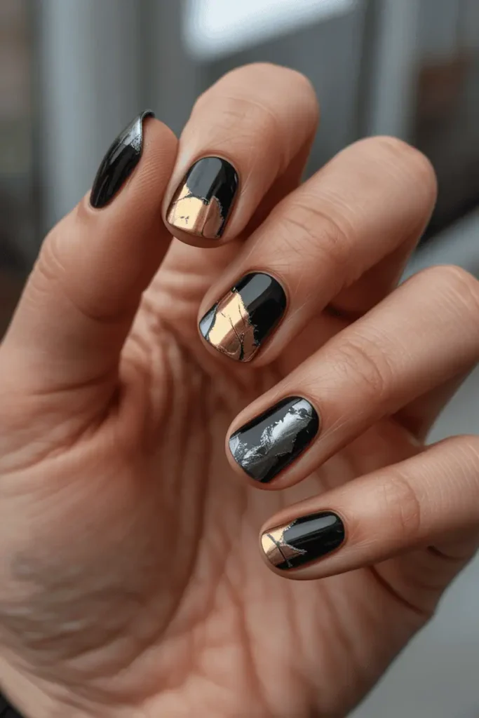 black nails with torn metallic foil accents in gold and silver, distressed industrial effect, edgy modern vibe, warm lighting, realistic hands, cozy minimal background