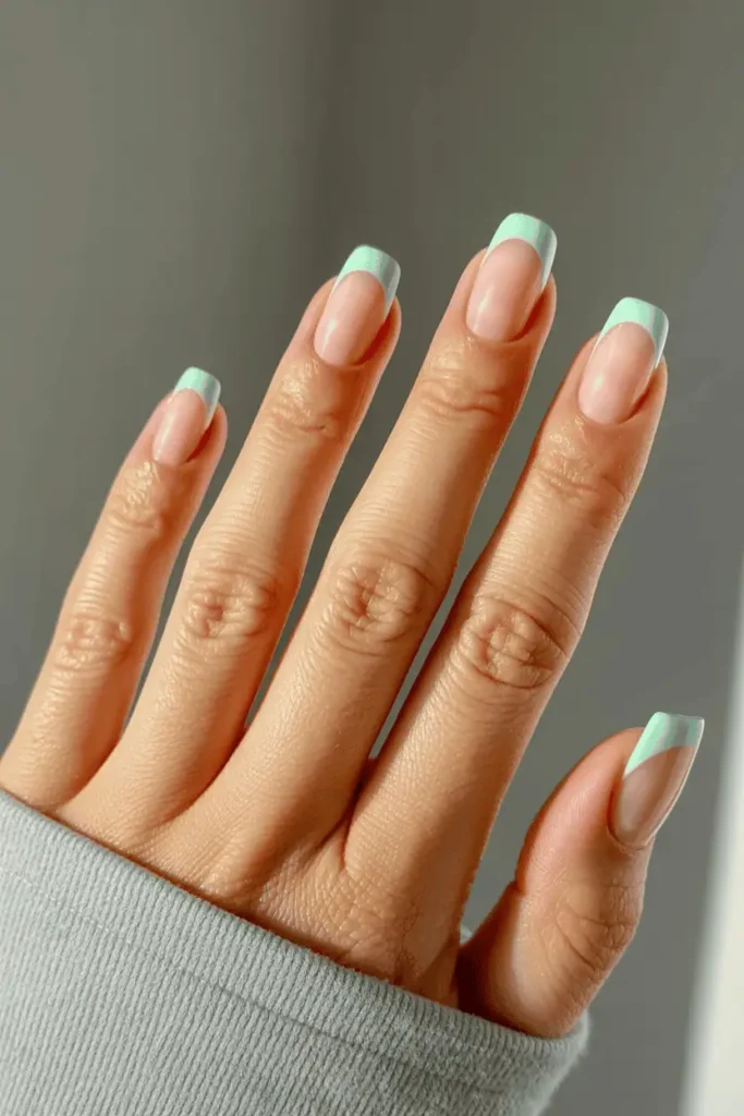 mint green pastel french tip nails, short nails with nude base, clean modern french manicure, soft spring color palette, natural daylight, neutral background, realistic nail photography, pinterest vertical 2:3, no text