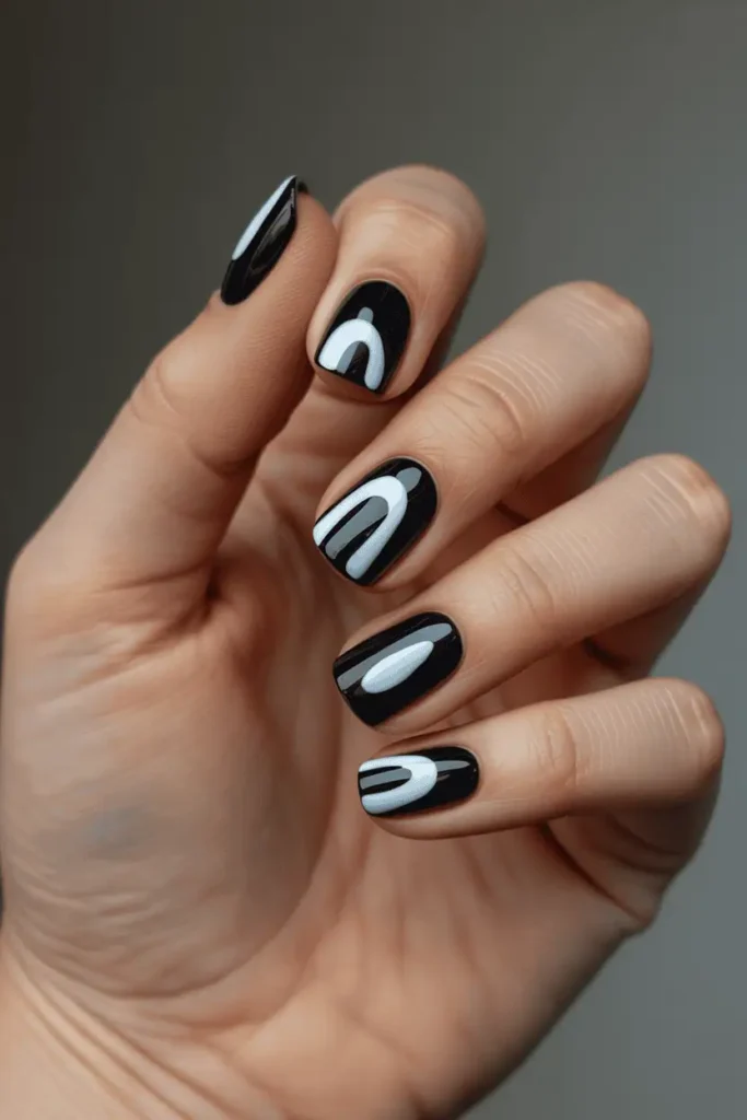 black nails with bold abstract negative space shapes, curved arches and open sections, high-contrast modern design, minimal background, realistic hands, editorial lighting