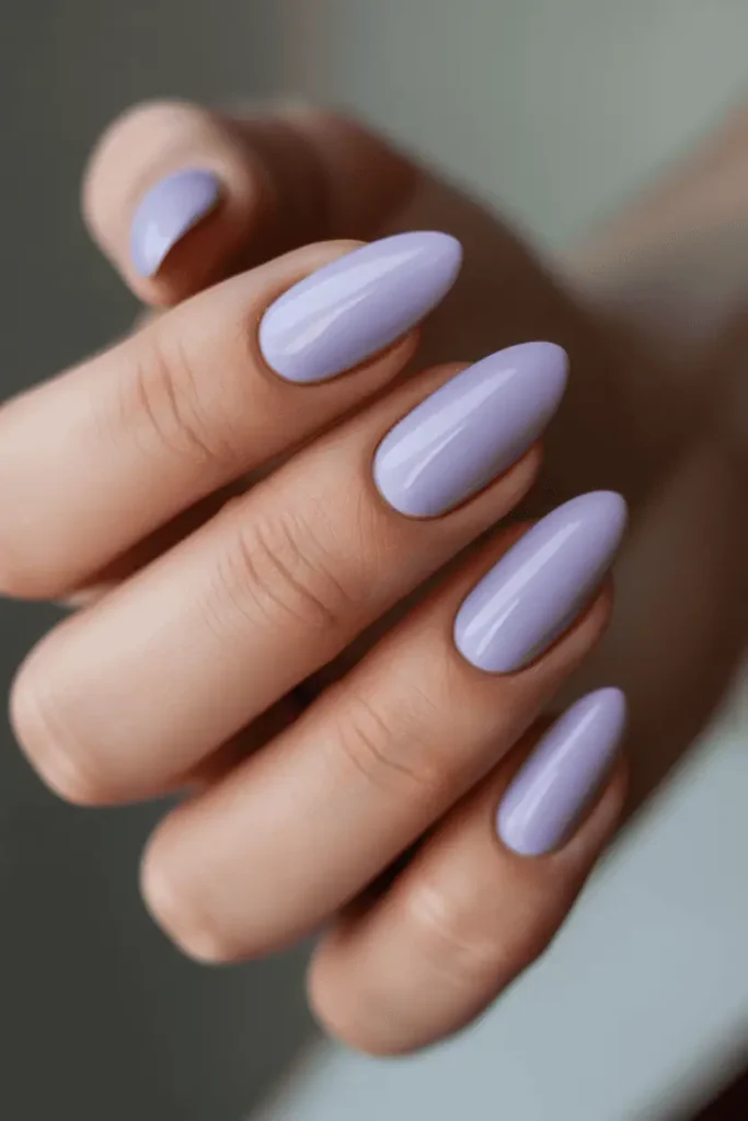 lavender pastel nails in glossy finish, almond nail shape, minimal clean manicure, soft spring lighting, blurred neutral background, realistic hand pose, professional nail photography, pinterest vertical 2:3 ratio, no text