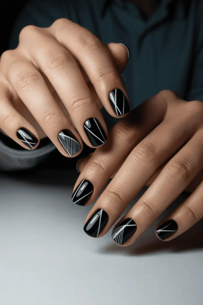 black nails with white geometric line art, sharp angles, diagonal stripes, architectural graphic design, minimalist modern style, clean background, realistic hands, soft spotlight lighting