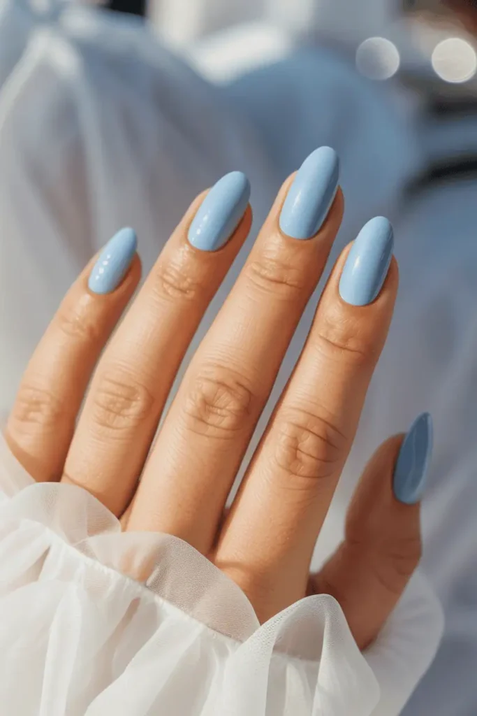 baby blue pastel nails with glossy shine, delicate cloud-like softness, realistic hands, airy bright background, soft bokeh light, spring aesthetic