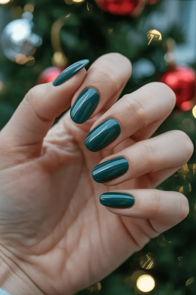 deep emerald green nails, glossy or velvet matte finish, luxe jewel tone, soft holiday decor background, warm festive lighting, realistic hands