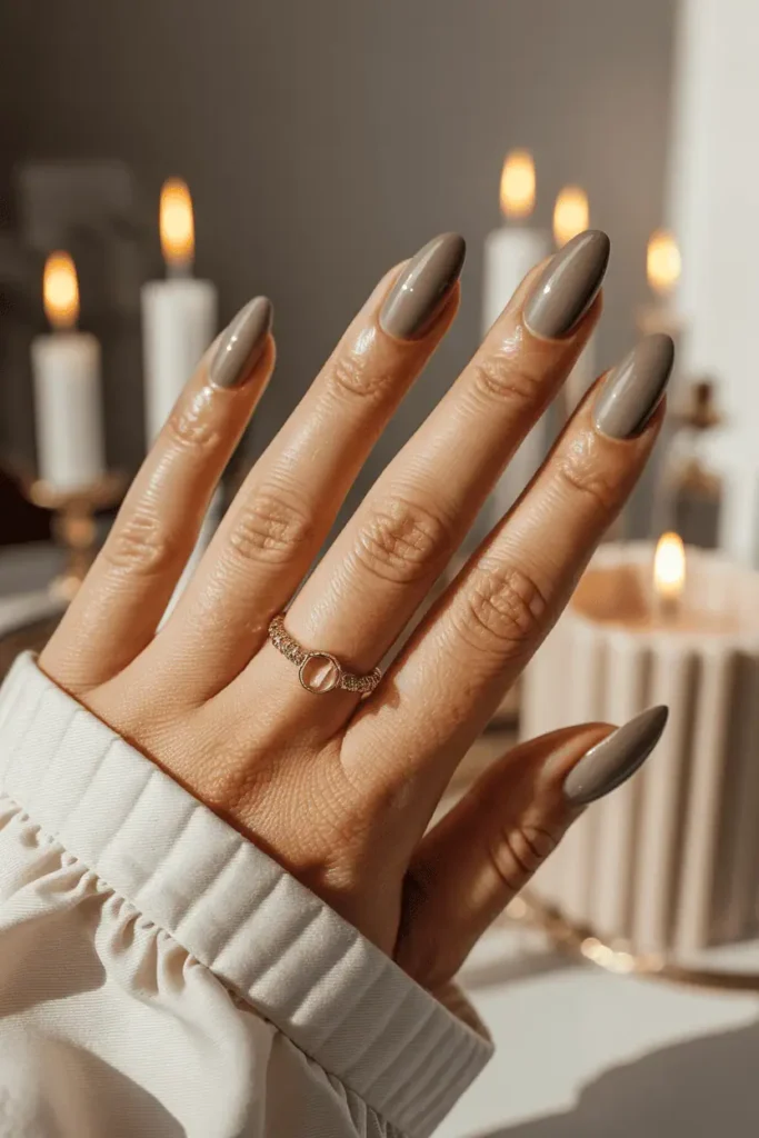 Taupe chrome nails, gentle metallic shine, elegant hand pose, neutral background.